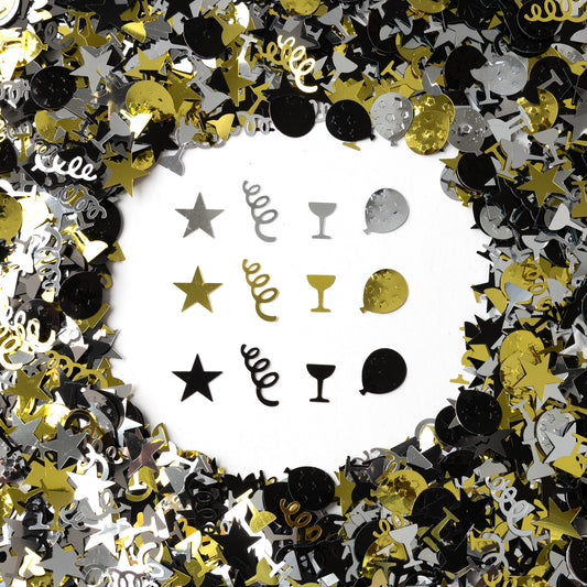 Metallic black, gold, and silver celebration confetti with stars, spirals, champagne glasses, and mixed shapes scattered on a white background