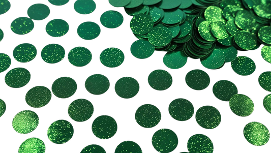 Luxe green circle confetti scattered on a white background with additional stacked pieces in the corner
