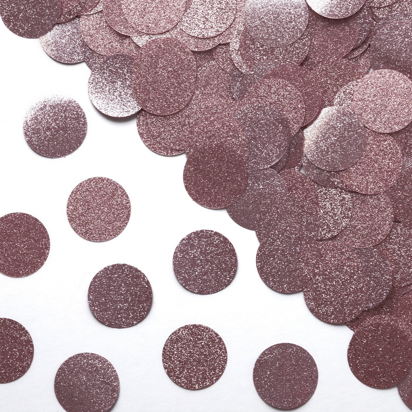Luxe rose gold glitter circle confetti in a close-up scattered pattern on a white background