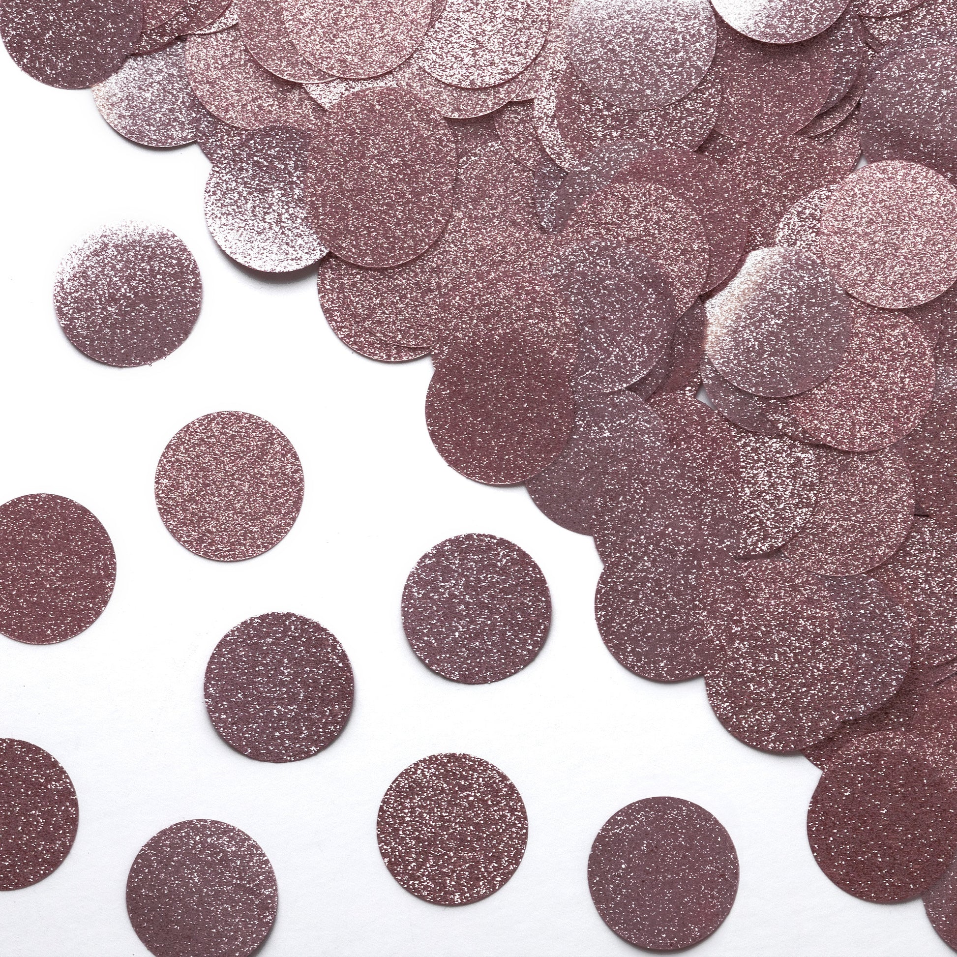 Luxe rose gold glitter circle confetti in a close-up scattered pattern on a white background