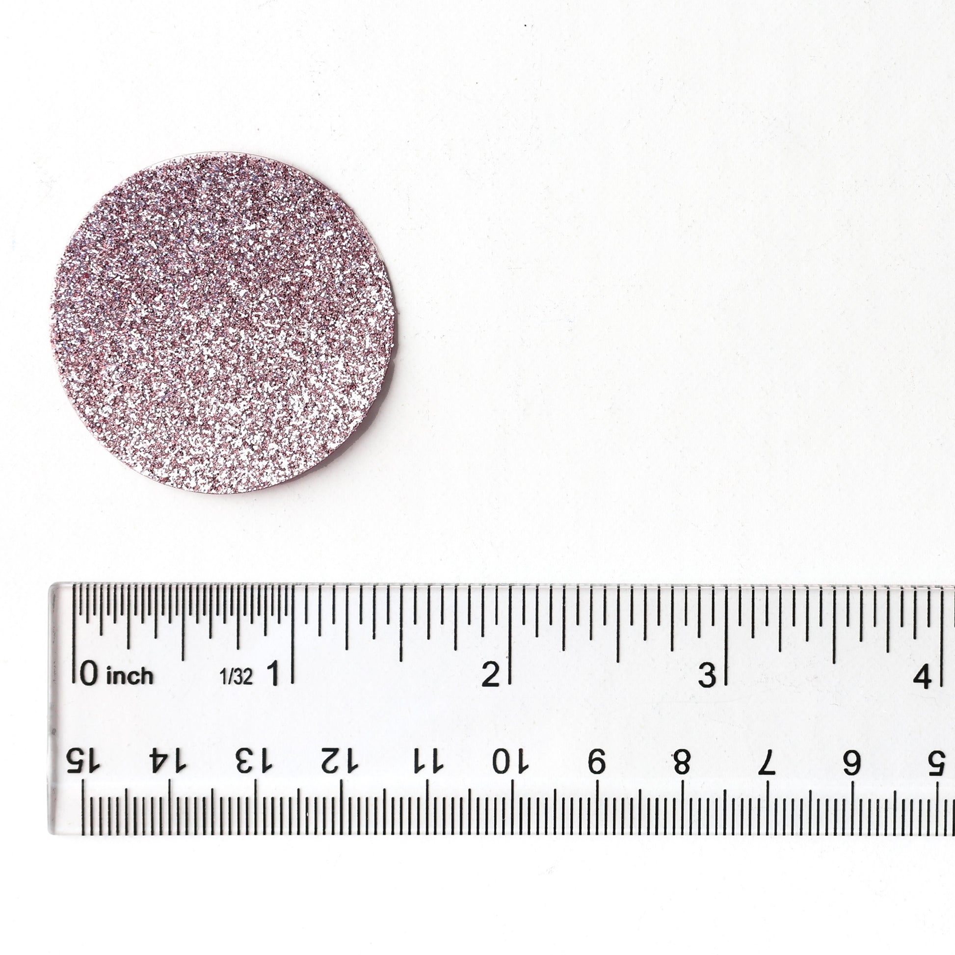 Luxe rose gold glitter circle confetti shown next to a ruler for size reference