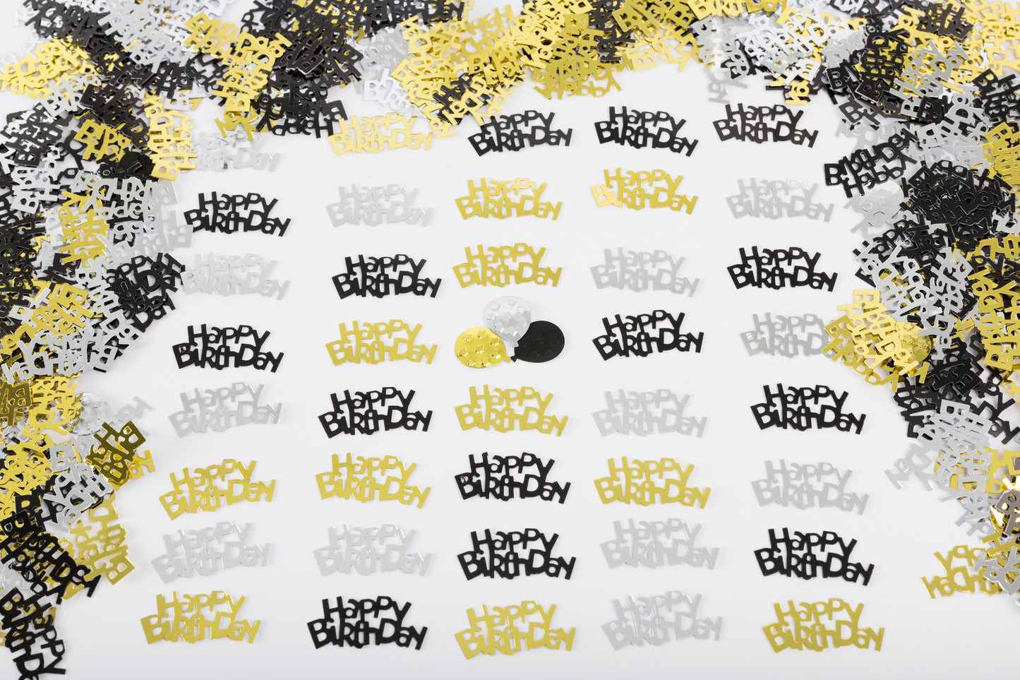 Metallic Happy Birthday confetti in black, gold, and silver evenly scattered on a white background