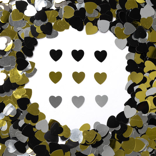 Metallic black, gold, and silver heart confetti displayed on a white background