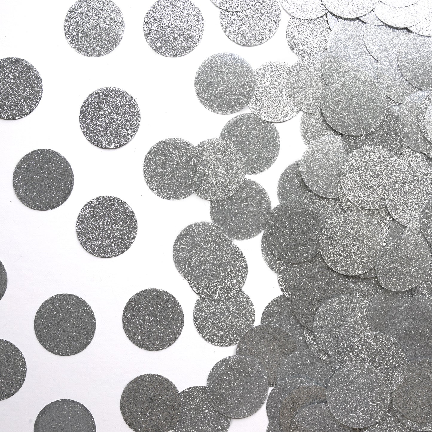 Metallic silver circle luxe confetti scattered on a white background