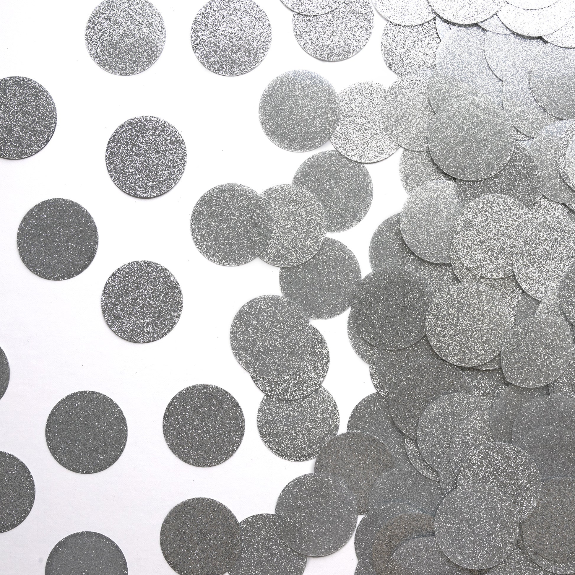 Metallic silver circle luxe confetti scattered on a white background