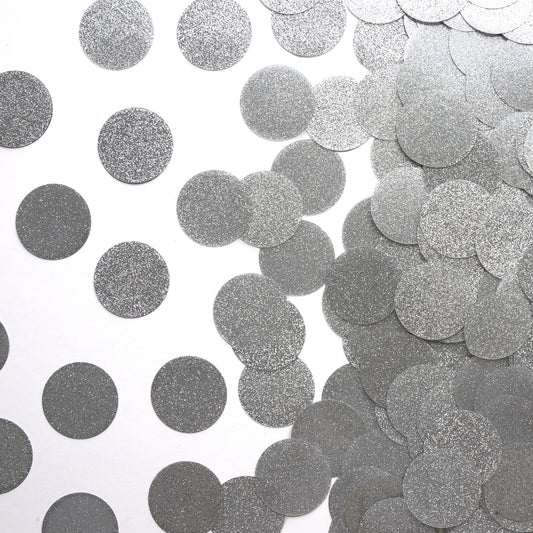 Metallic silver circle luxe confetti scattered on a white background