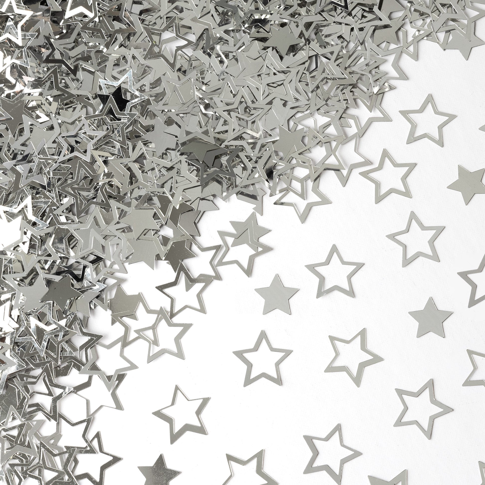 Metallic silver star confetti in hollow and solid shapes spread across a white background