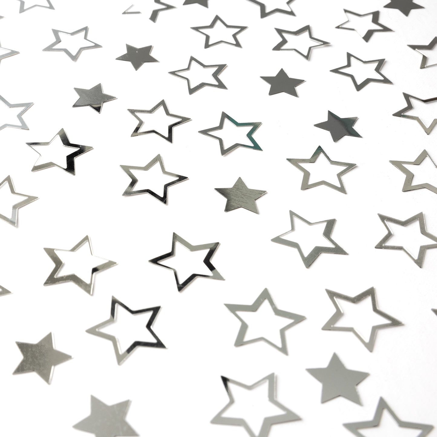 Metallic silver star confetti in mixed hollow and solid shapes spread across a white background