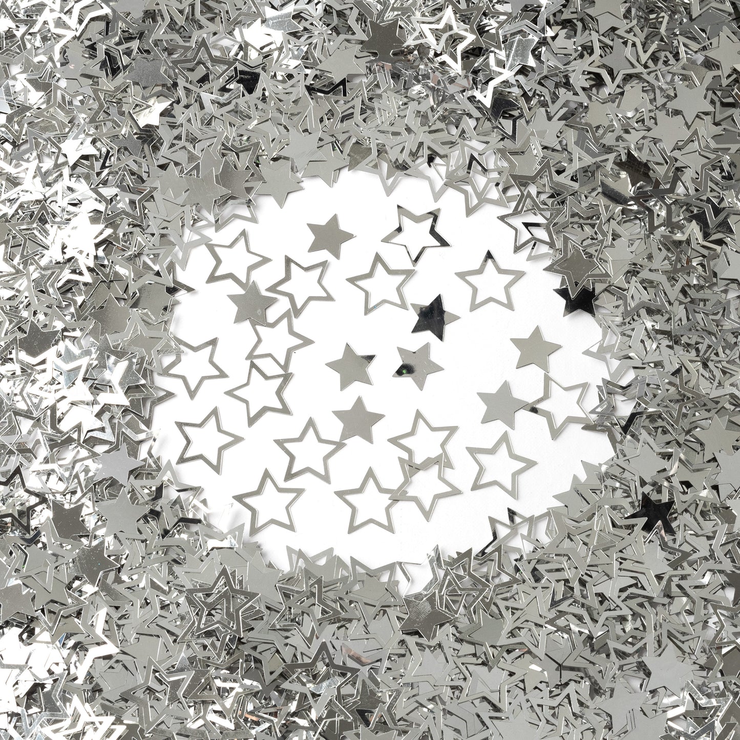 Metallic silver star confetti in mixed hollow and solid shapes arranged on a white background